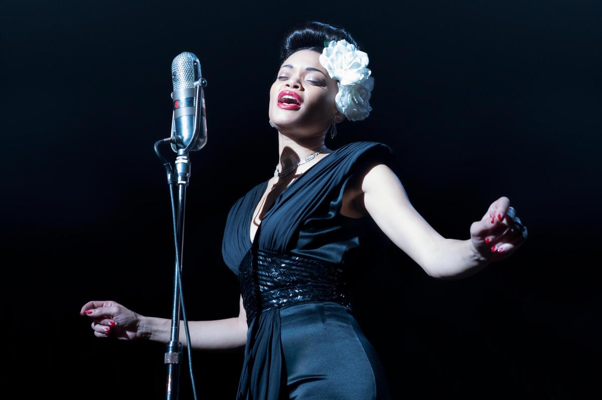 Andra Day in a black gown singing at a microphone in a scene from "The United States vs. Billie Holiday."