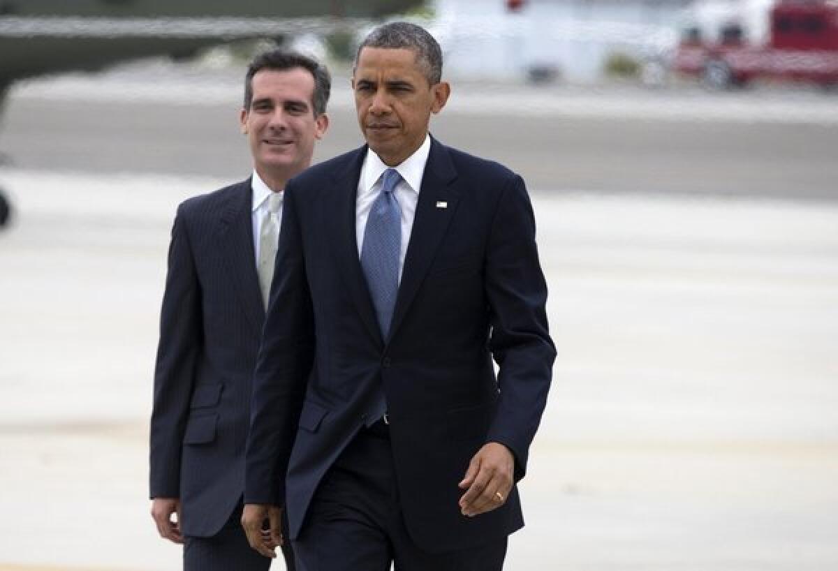 President Obama walks with Los Angeles Mayor-elect Eric Garcetti after arriving aboard Marine One in Santa Monica on June 7, 2013.