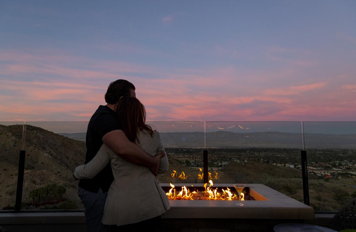  A couple enjoys the view and the warmth of an outdoor fire pit at the Ritz-Carlton in Rancho Mirage.