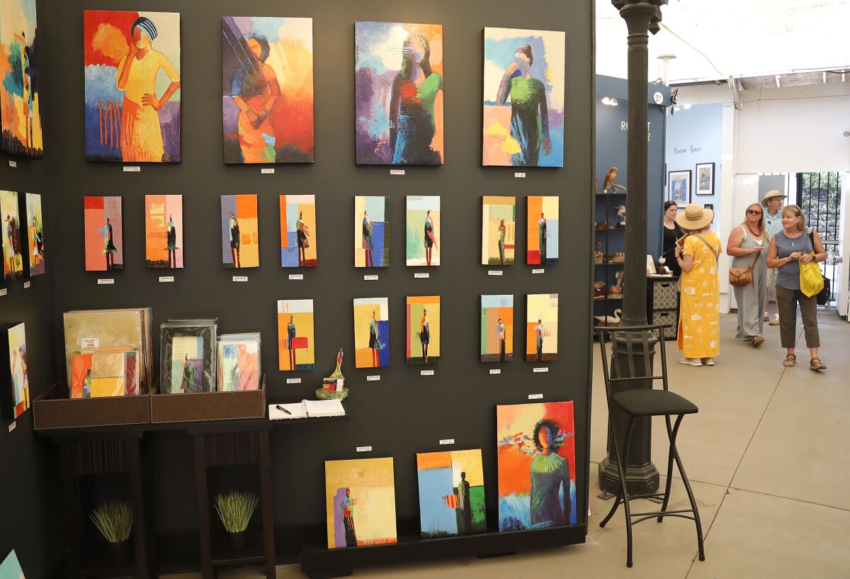 Artist Tim Genet's figures of mixed-media oil paintings at the show in July 2021.