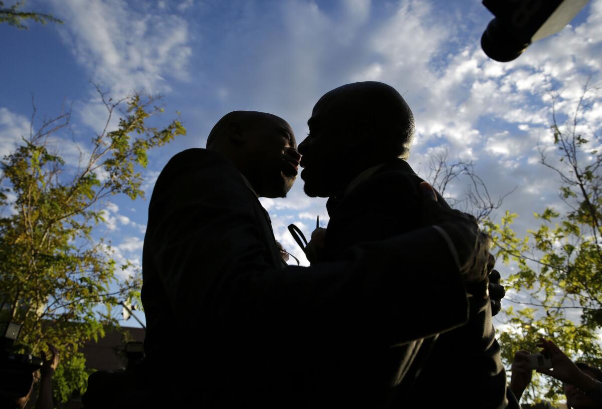 Sherwood Howard, left, embraces Nevada State Sen. Kelvin Atkinson as they get married Thursday outside the Marriage License Bureau in Las Vegas. They were the first same-sex couple to marry in Las Vegas.