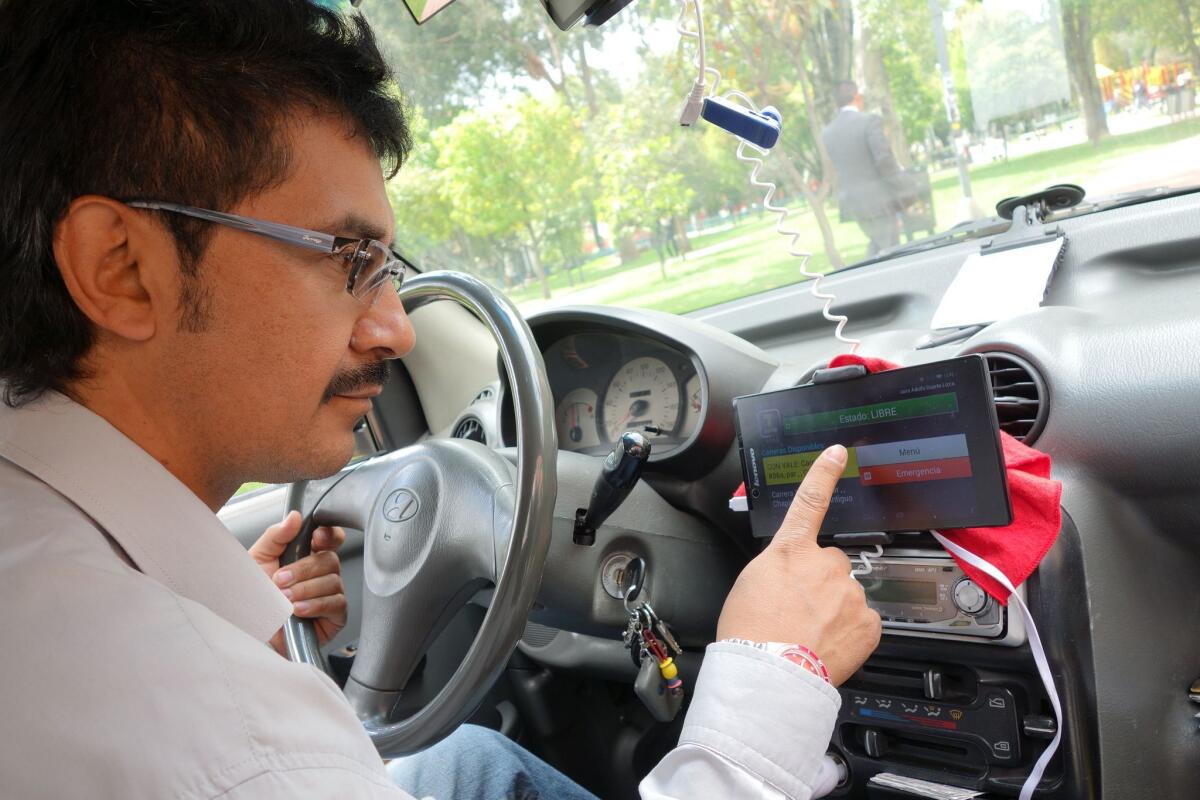 Bogota driver Jairo Duarte checks a fare opportunity coming over his Tappsi Internet-GPS service, one of several ride-share apps available in the Colombian capital.