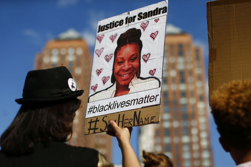 A woman with a poster bearing Sandra Bland's image during a Michael Brown memorial rally in New York on Sunday.