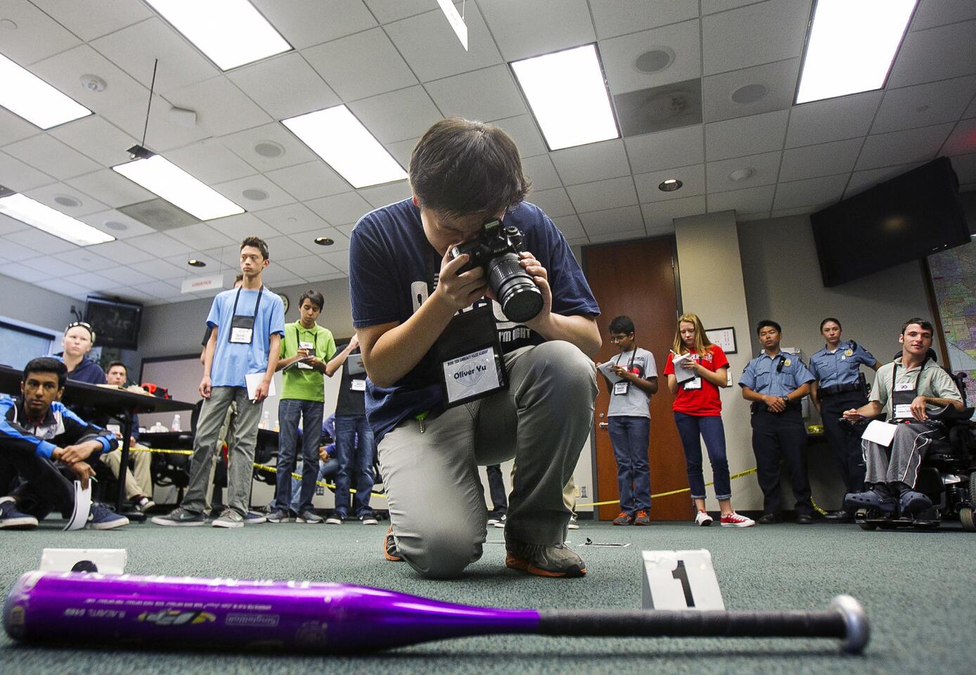 Oliver Yu takes photos of evidence at a mock crime scene using CSI techniques during the Teen Community Police Academy put on by Irvine Police on Tuesday, August 11.