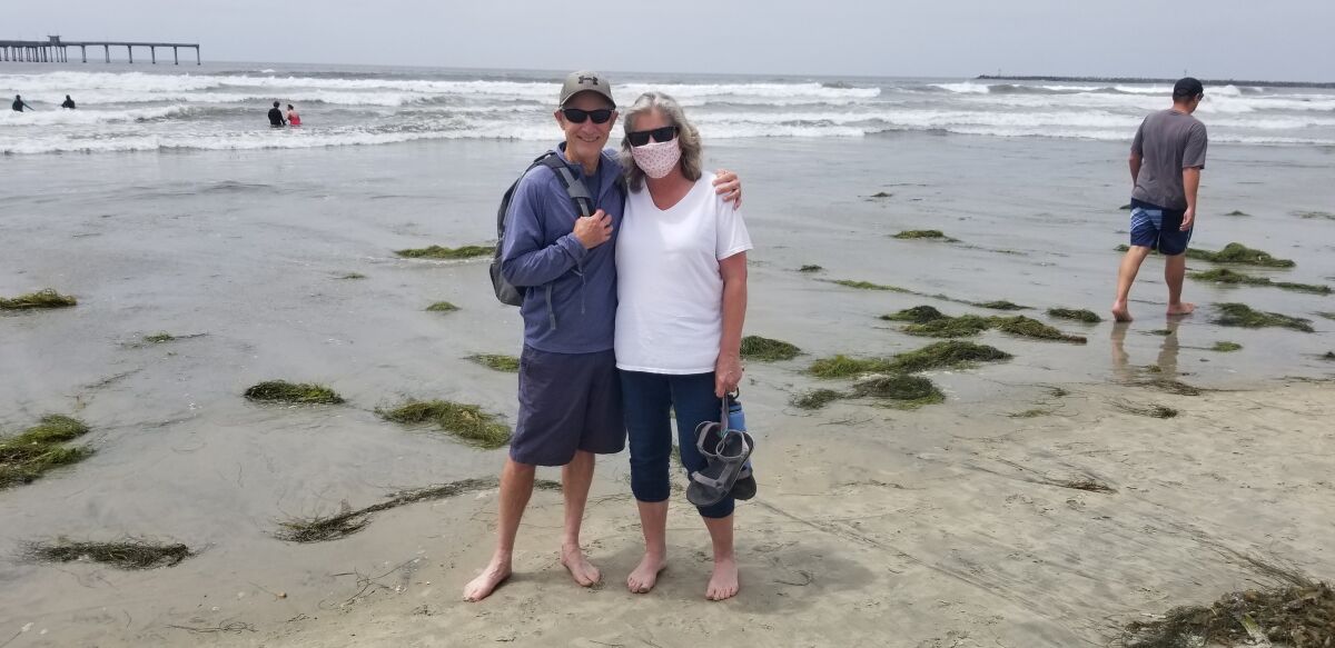 John Finch and Jane Richmond go for a stroll along the sand in Ocean Beach.