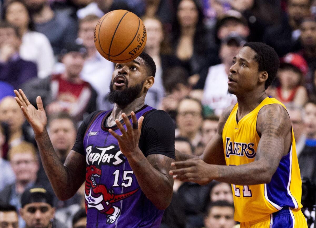 Forwards Amir Johnson (15) of the Raptors and Ed Davis of the Lakers keep their eye on a loose ball in the first half Friday night in Toronto.