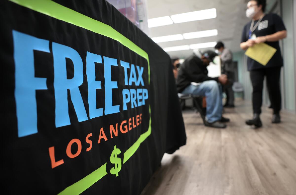 A banner reads "Free Tax Prep Los Angeles" as people wait for assistance with their taxes.