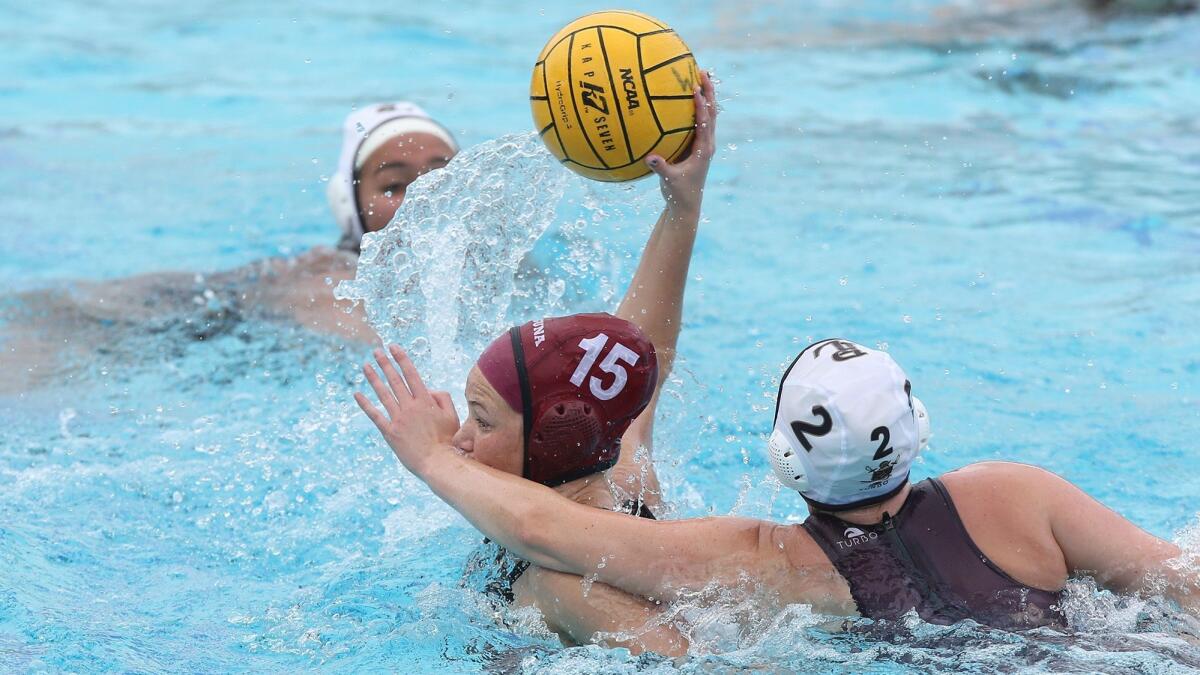 Laguna Beach High's Claire Kelly shoots and scores despite a hand in the face by Point Loma's Kristin Smith in a CIF Southern California Regional Division II playoff opener at Corona del Mar High on Friday.