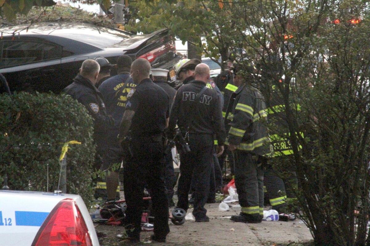 First responders examine a car after its driver lost control and plowed into a group of trick-or-treaters in New York. Three people were killed.