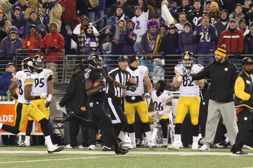 Pittsburgh Steelers head coach Mike Tomlin (right) has his back turned from the play as Baltimore Ravens' Jacoby Jones (12) is pursued by Pittsburgh Steelers' Cortez Allen on a kickoff return during the third quarter.