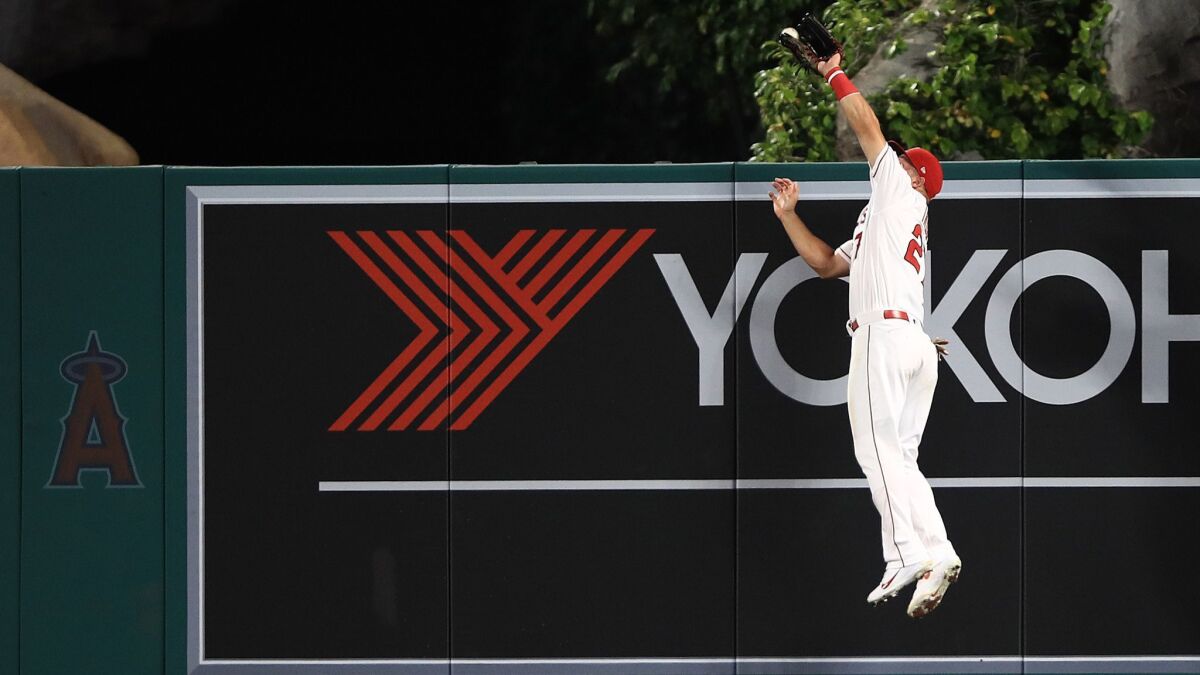 Mike Trout of the Angels catches a fly ball hit by Christian Yelich of the Milwaukee Brewers at Angel Stadium.