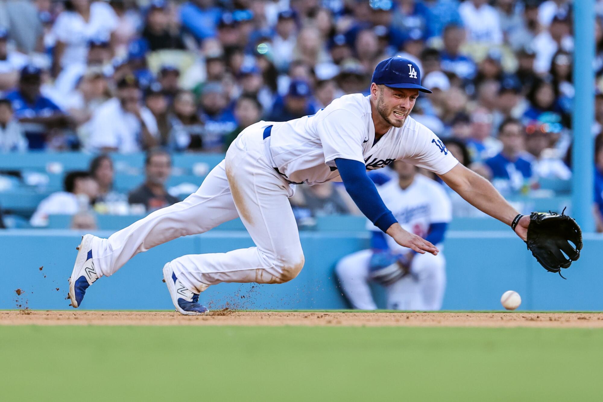Dodgers third baseman Michael Busch dives in vain for an 11th inning single by Houston Astros first baseman Jose Abreu.