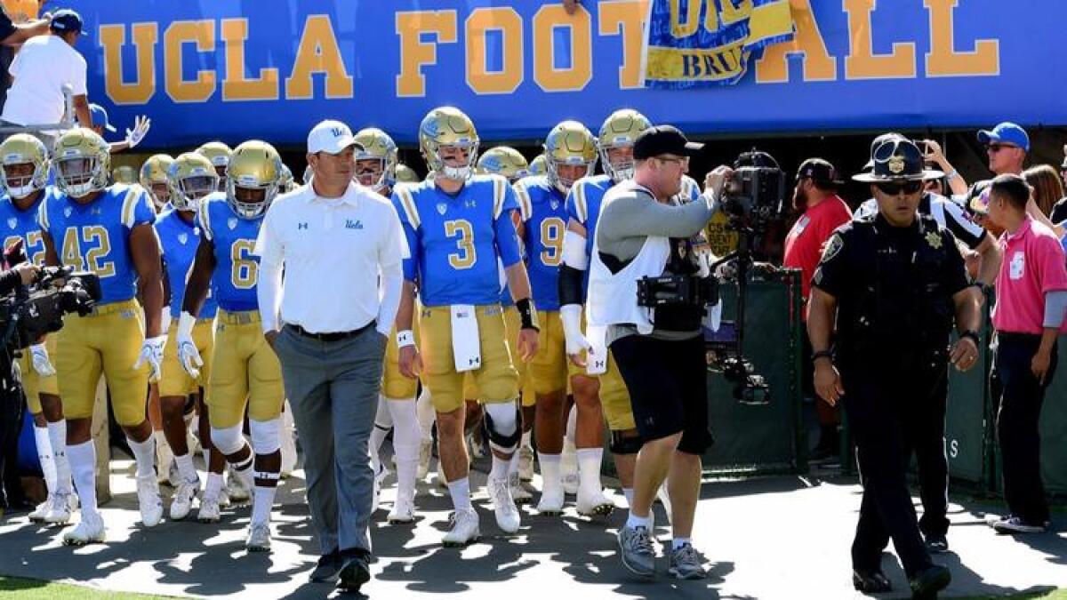 UCLA coach Jim Mora leads his team onto the field before the game against the Oregon Ducks at the Rose Bowl on Oct. 21.