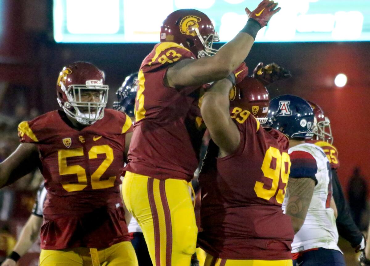 USC senior defensive linemen Delvon Simmons (52), Greg Townsend Jr. (93) and Antwaun Woods (99) celebrate a sack by Woods against Arizona.