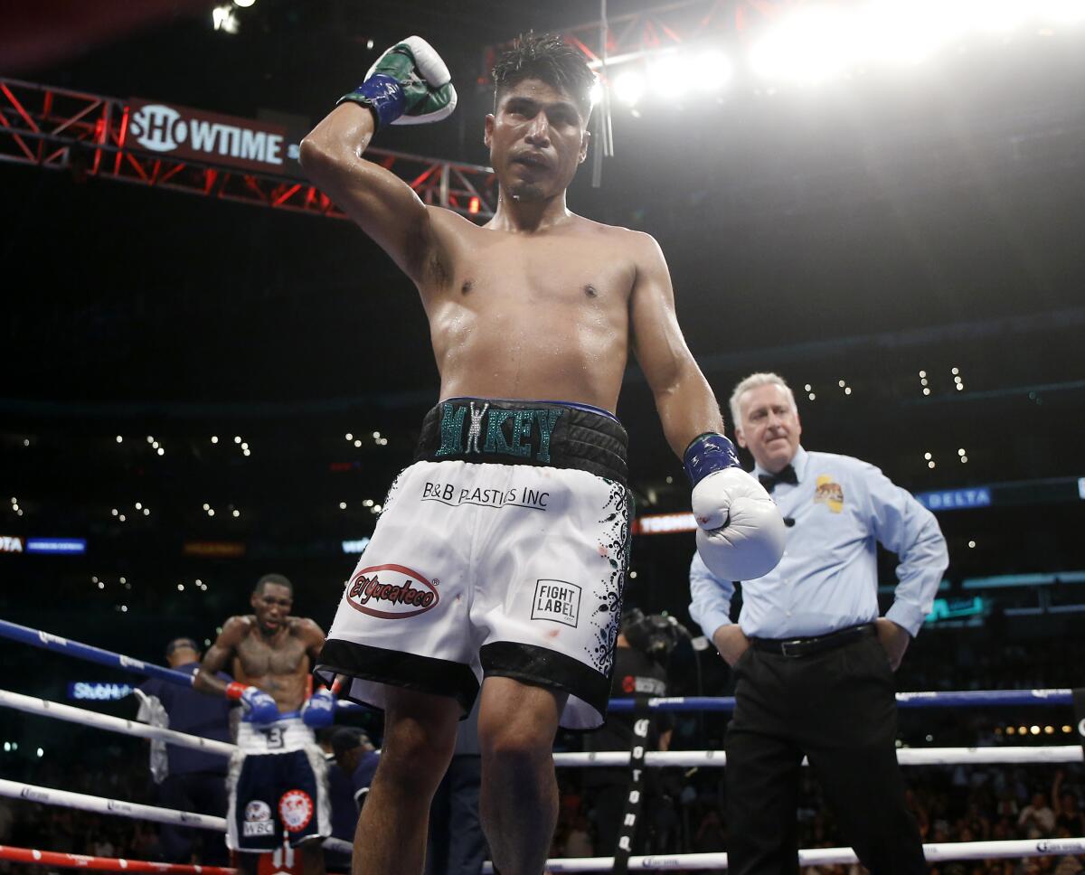 Mikey Garcia, center, raises his arm after the 11th round against Robert Easter Jr. 