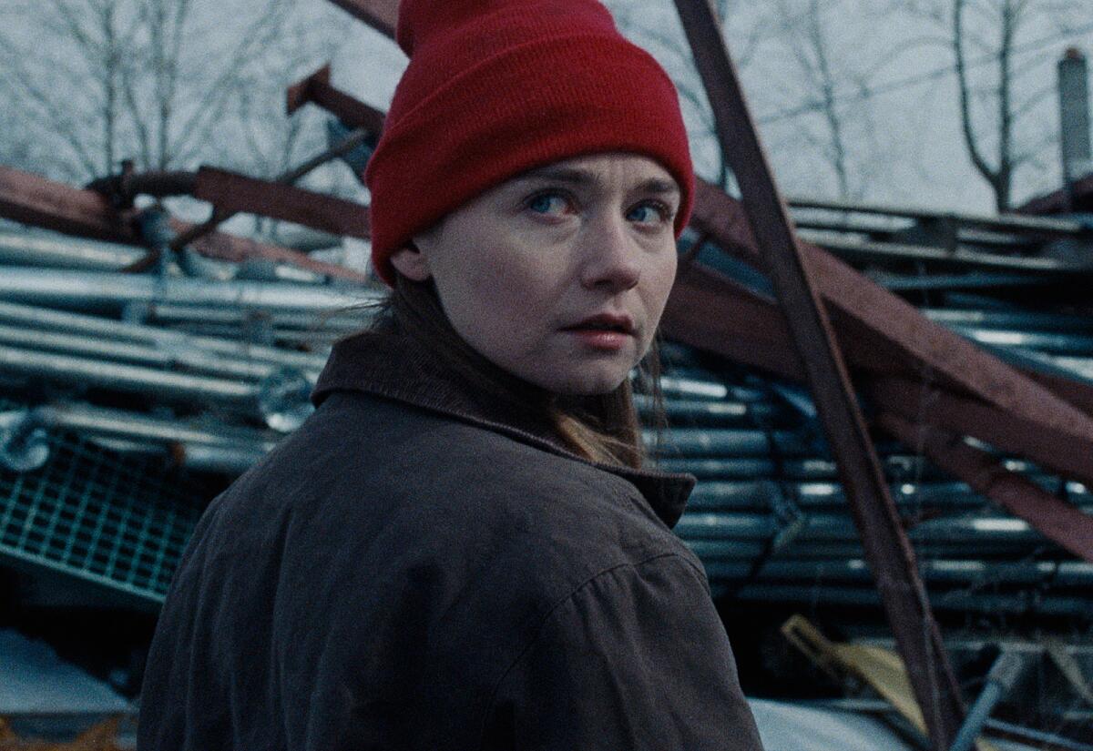 A young woman in a knit cap looks back over her right shoulder in the movie "Holler."