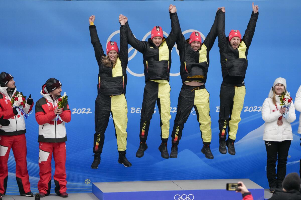Germany's Natalie Geisenberger, Johannes Ludwig, Tobias Wendl and Tobias Arlt jump on the podium.