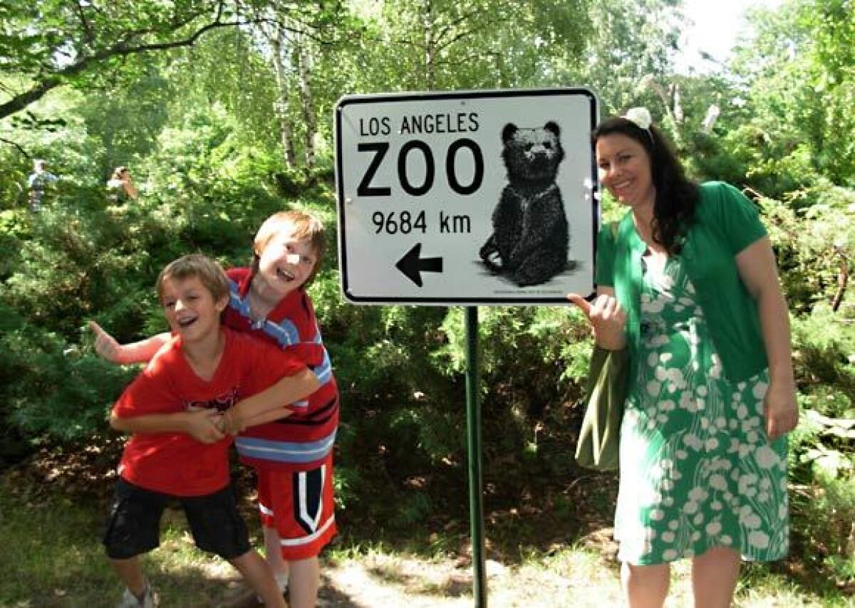 At the Berlin Zoo, new friends Corrie, son Jake and the writer’s son, Carpenter, left, get silly at a sign for the L.A. Zoo.