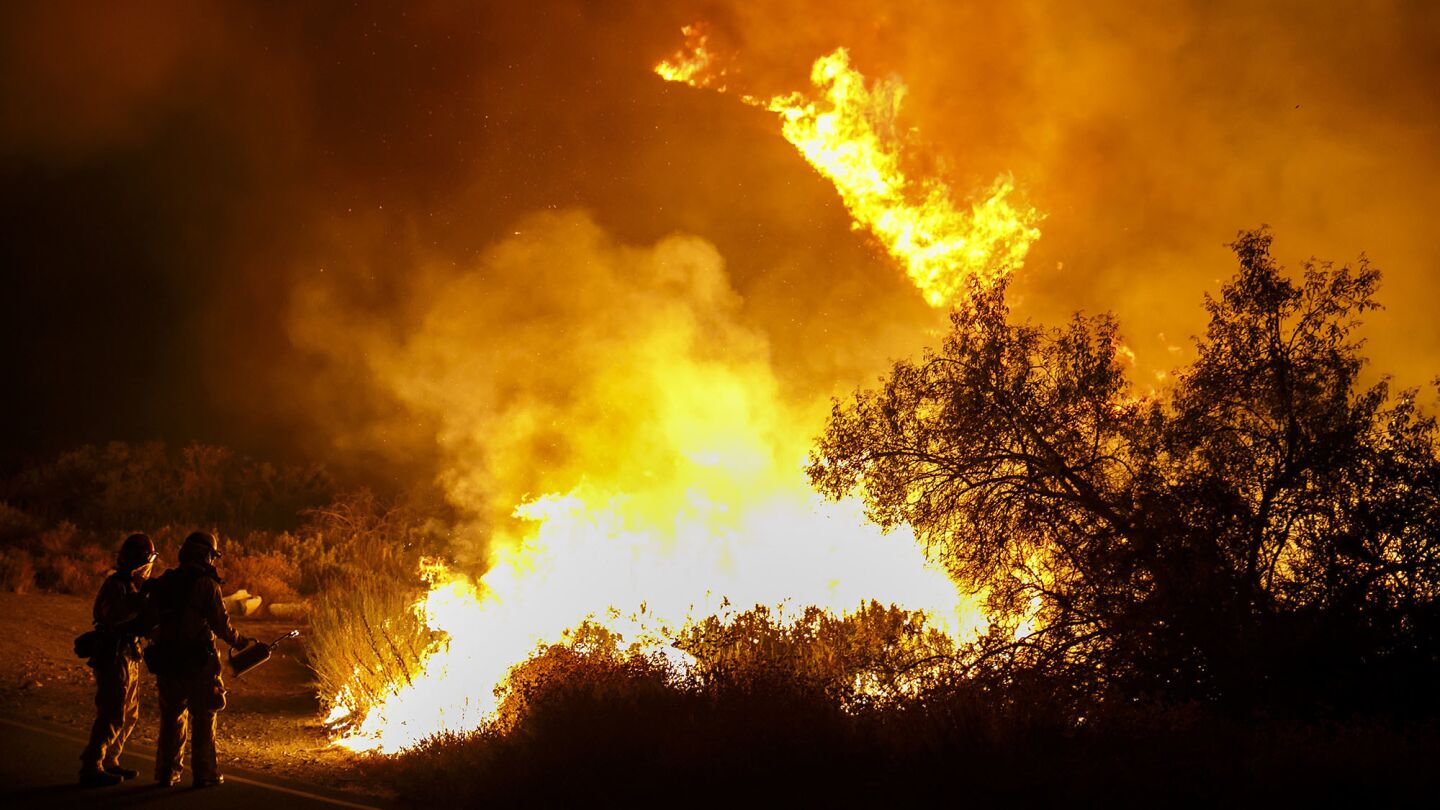 Firefighters set back fires on Lytle Creek Road on Wednesday night.