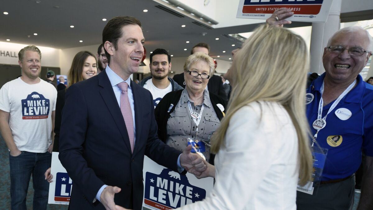 Democratic congressional candidate Mike Levin, in tie, talks with his wife Chrissy Levin in front of supporters at the 2018 California Democrats State Convention in February.