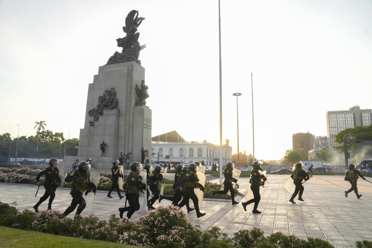 La policía carga para dispersar a manifestantes de oposición al gobierno en Lima, Perú