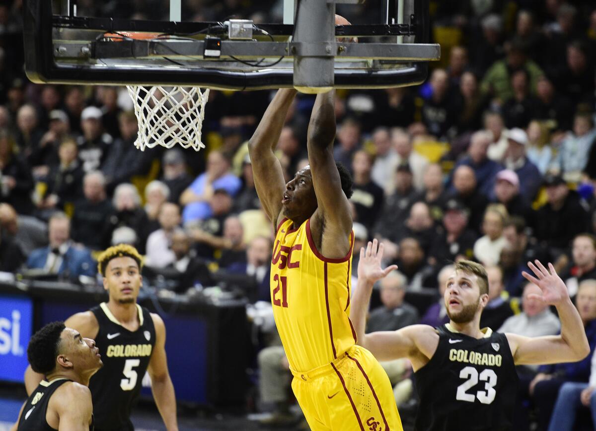 Colorado's Tyler Bey, left, D'Shawn Schwartz, and Lucas Siewert, look on as USC's Onyeka Okongwu dunks during the first half on Thursday in Boulder, Colo.