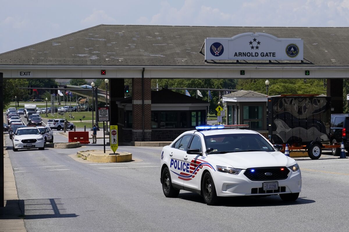 A Metropolitan Police Department cruiser drives out of an entrance to Joint Base Anacostia-Bolling during a lockdown, Friday, Aug. 13, 2021, in Washington. The base was placed on lockdown after a report that an armed person was spotted on the base. (AP Photo/Patrick Semansky)