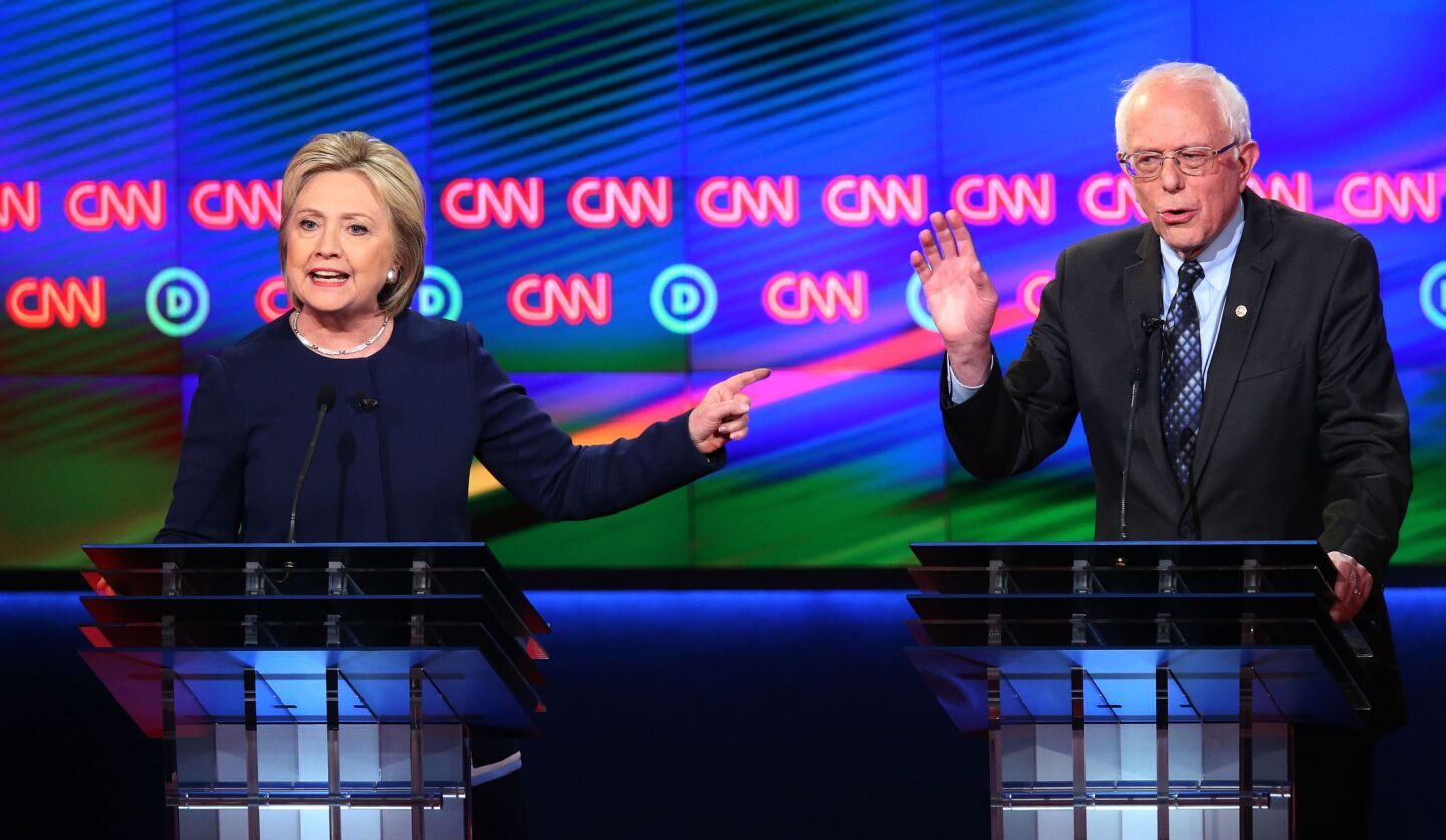 Democratic presidential candidate Hillary Clinton and Senator Bernie Sanders speak during the CNN Democratic Presidential Primary Debate at the Whiting Auditorium at the Cultural Center Campusin Flint, Mich.