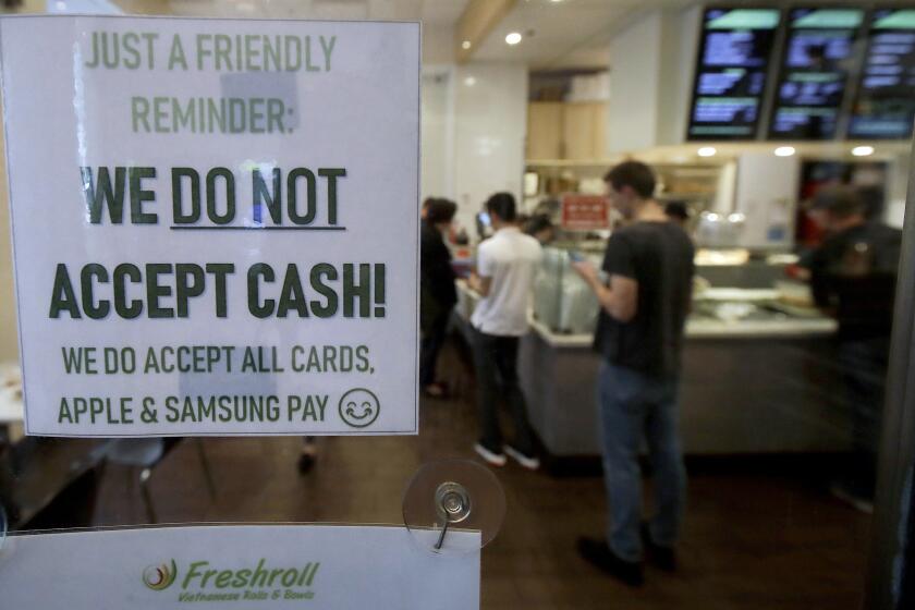 This Thursday, May 2, 2019, photo shows a sign posted on a door alerting customers that cash is not accepted at Freshroll Vietnamese Rolls and Bowls in San Francisco. San Francisco is about to require brick-and-mortar retailers to take cash in payment for goods, joining Philadelphia and New Jersey in banning a practice that critics say discriminates against the poor. (AP Photo/Jeff Chiu)