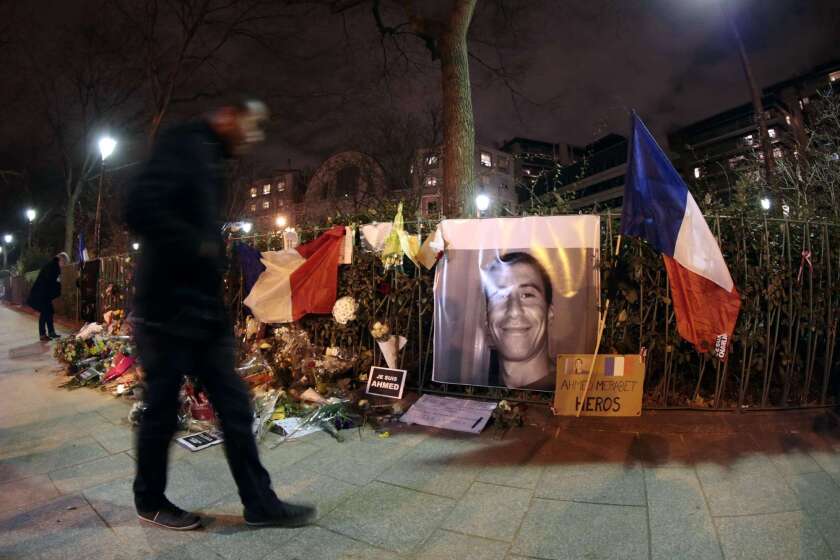 A man walks past a makeshift memorial for French policeman Ahmed Merabet on Jan. 11 near the site where the officer was shot to death by gunmen close to the headquarters of the French satirical weekly Charlie Hebdo four days earlier.