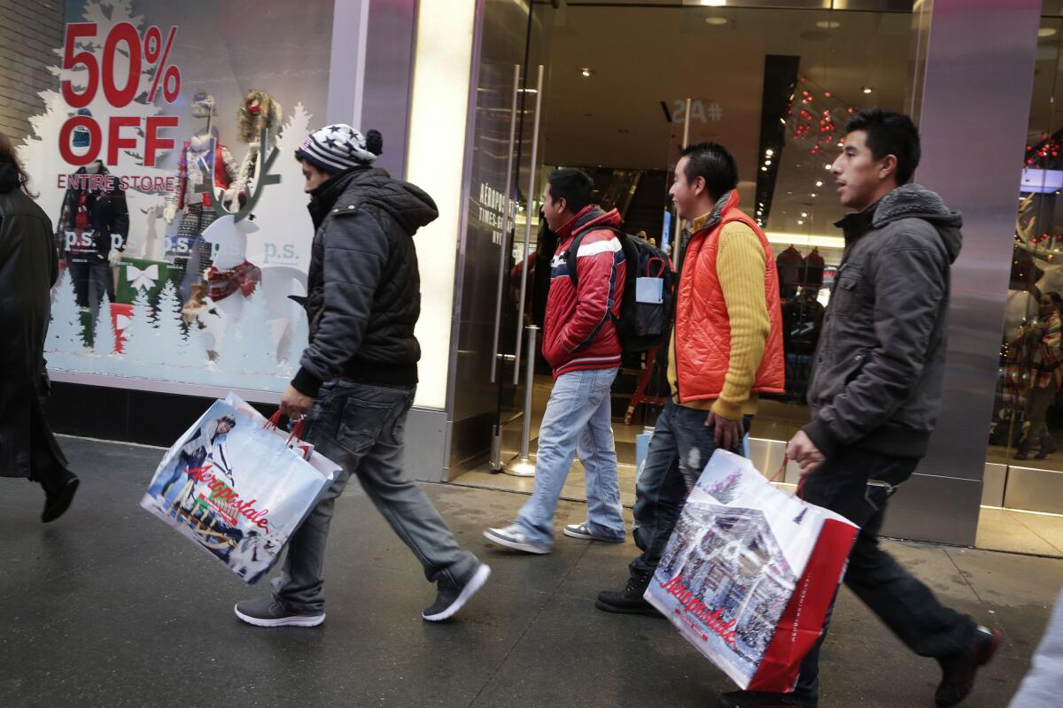 Shoppers carry their bags as they leave the Aeropostale clothing store in New York's Times Square on Dec. 2, 2015.