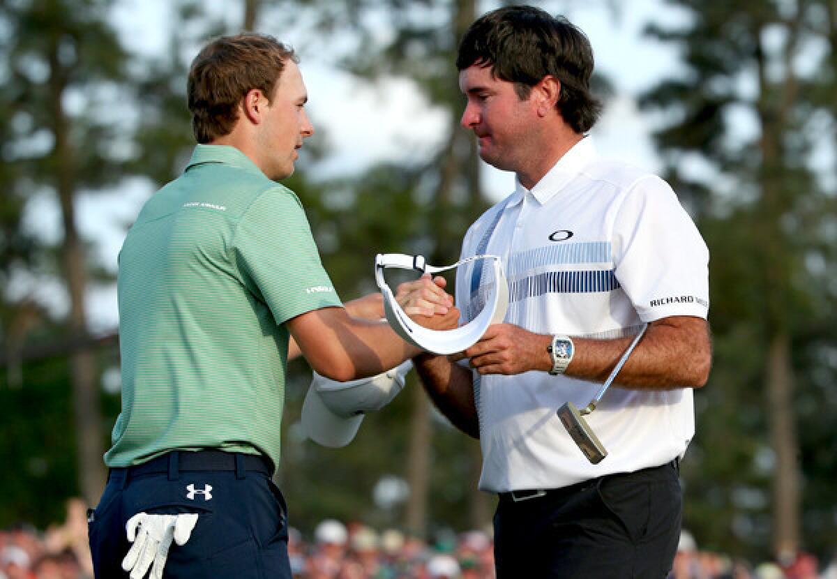 Two-time Masters champion Bubba Watson tries to keep his composure as runner-up Jordan Spieth, left, congratulates him after the completion of their round Sunday at Augusta National Golf Club.