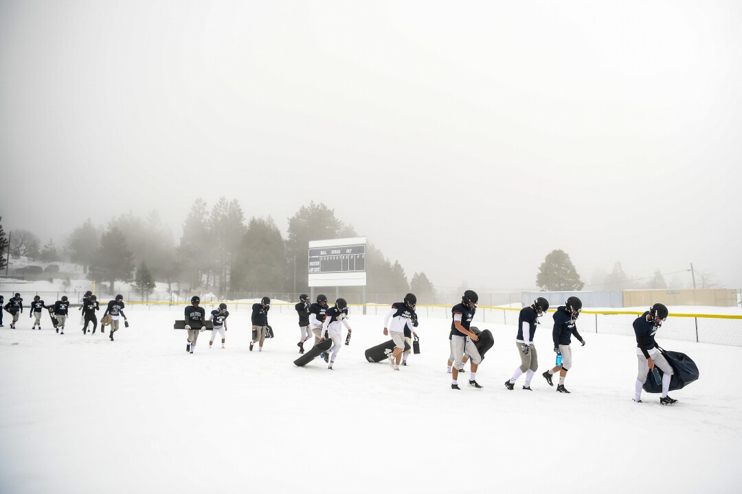 March 16: Football players walk on fallen snow to a practice field.