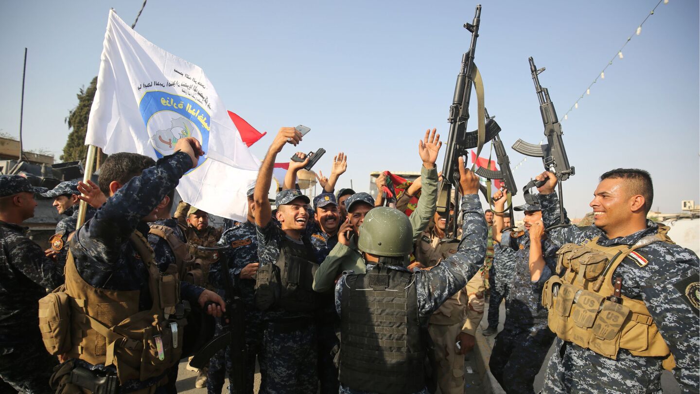 Iraqi federal police members celebrate in the embattled city of Mosul after the victory announcement.