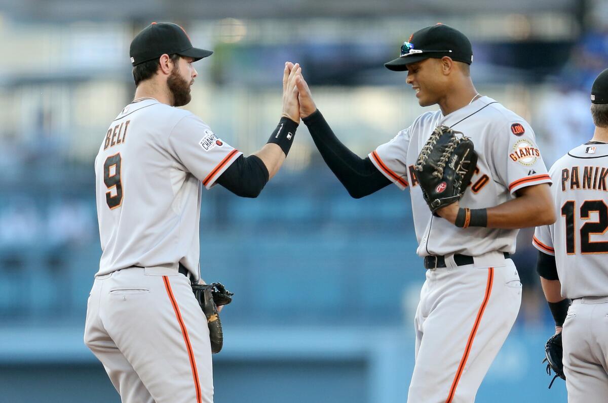 San Francisco first baseman Brandon Belt and outfielder Justin Maxwell celebrate after beating the Dodgers, 6-2, on Saturday at Dodger Stadium.