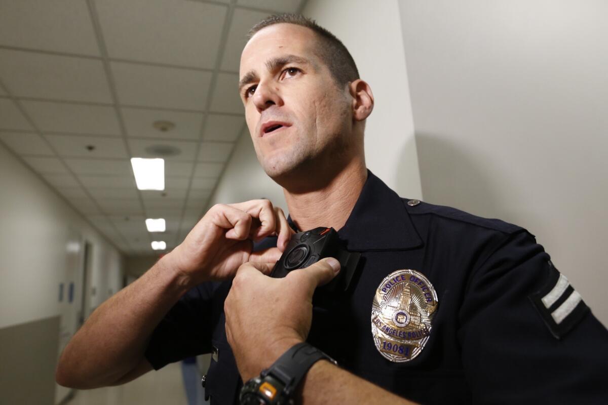 LAPD Officer Jim Stover demonstrates his new body camera at Mission Division headquarters in August.
