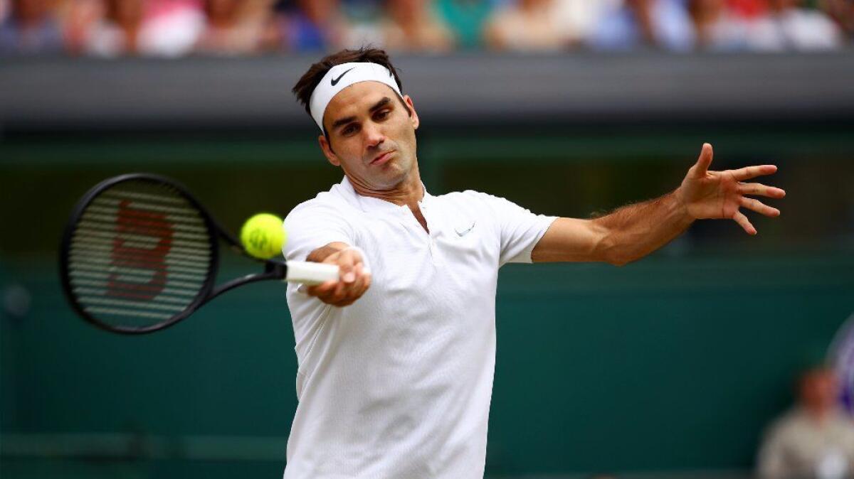 Roger Federer returns to Marin Cilic during their men's singles final match at the Wimbledon Championships at The All England Lawn Tennis Club.