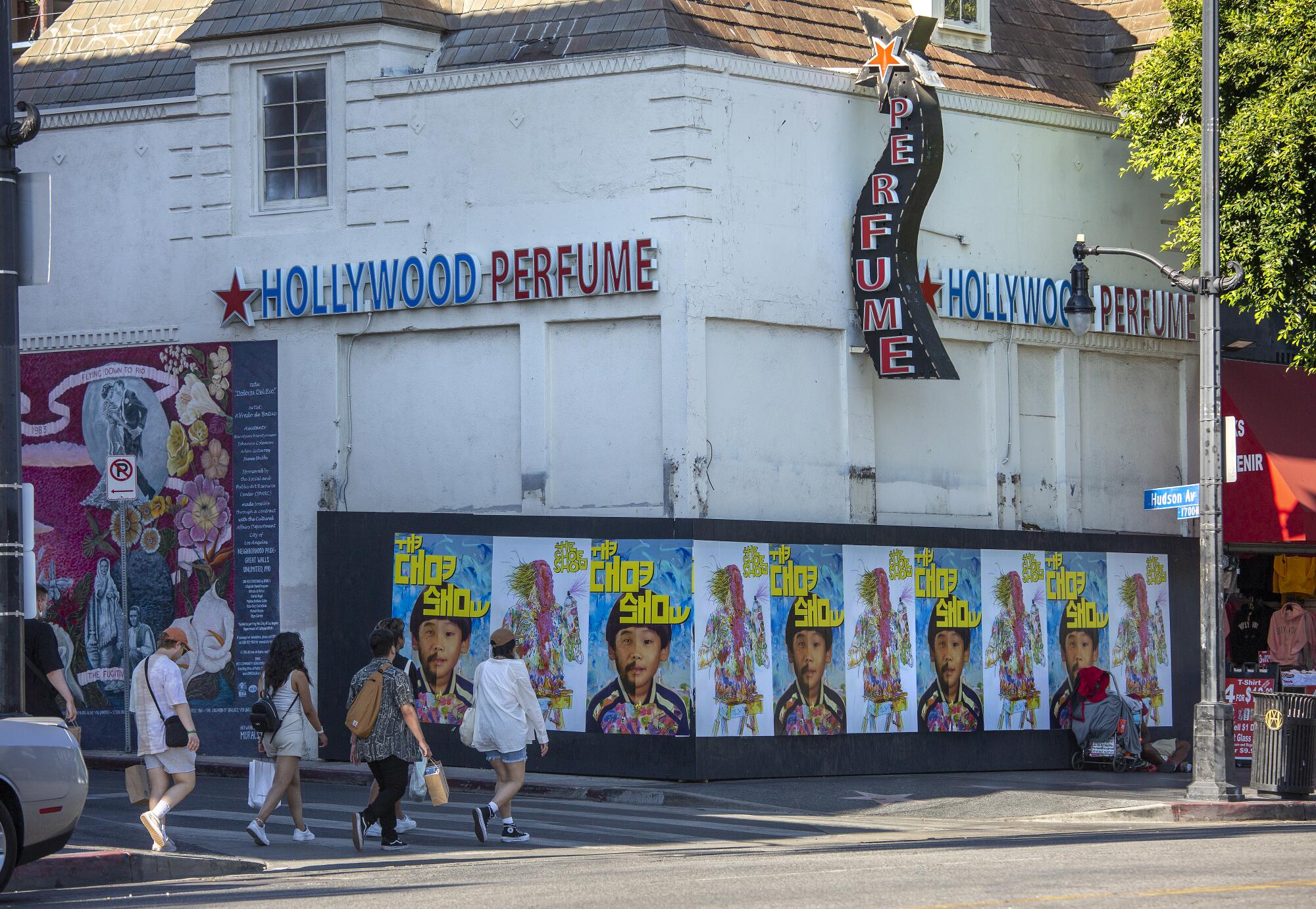 People walk past a boarded up storefront on Hollywood Boulevard in Hollywood.