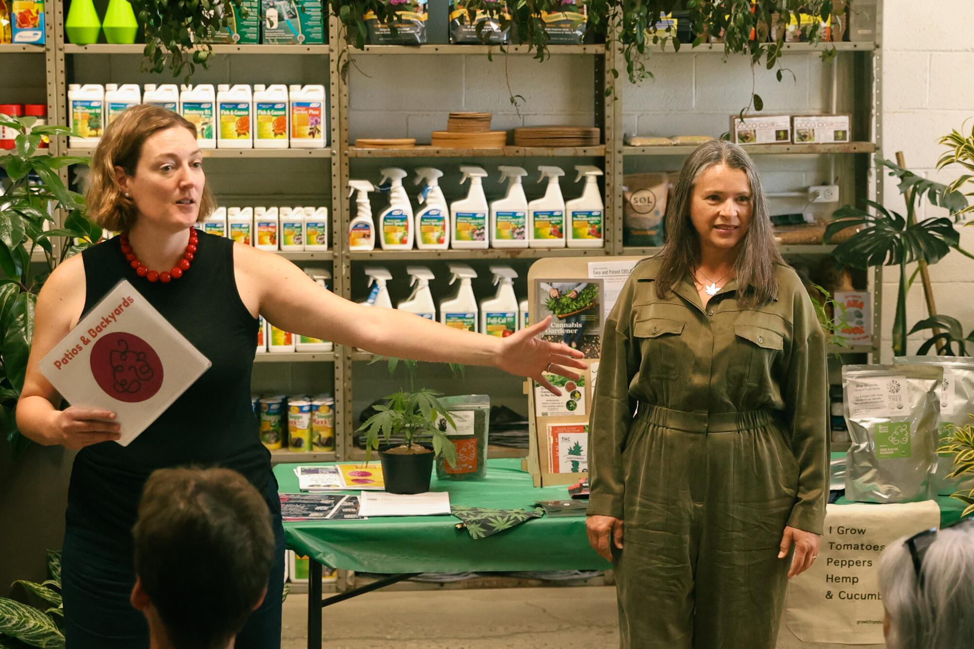 Two people standing in a gardening center surrounded by gardening supplies.