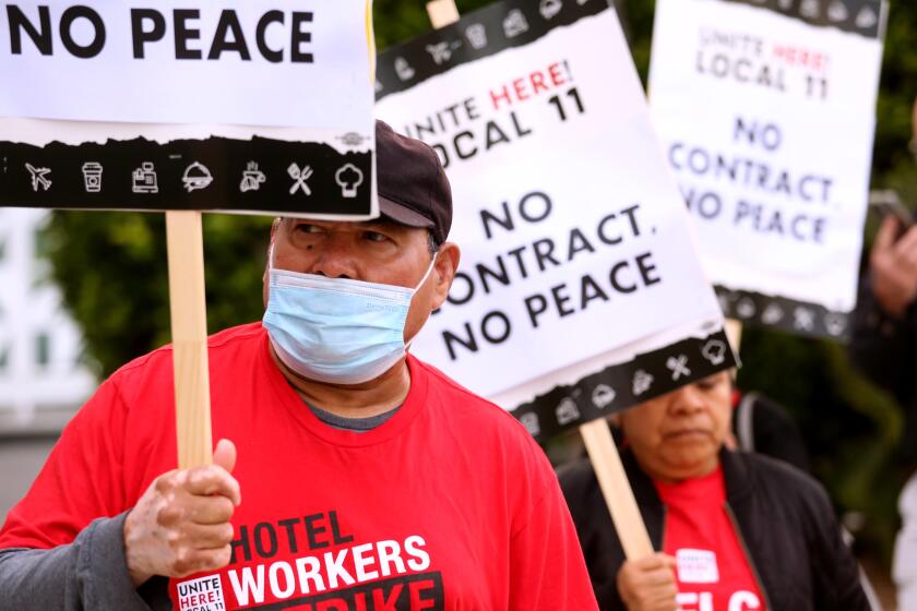 SANTA MONICA, CA - JULY 12, 2023 - Jose Ayala, 66, left, walks the picket line with fellow Unite Here Local 11 hotel workers in front of the Viceroy Hotel in Santa Monica on July 12, 2023. Ayala works as a dishwasher for the Viceroy Hotel and has to work a second job to make ends meet. Some older hotel workers scrape by on their income and can't afford to quit. Some work two jobs just to make ends meet. Unite Here Local 11 hotel employees have been striking for higher pay and better benefits. (Genaro Molina/Los Angeles Times)