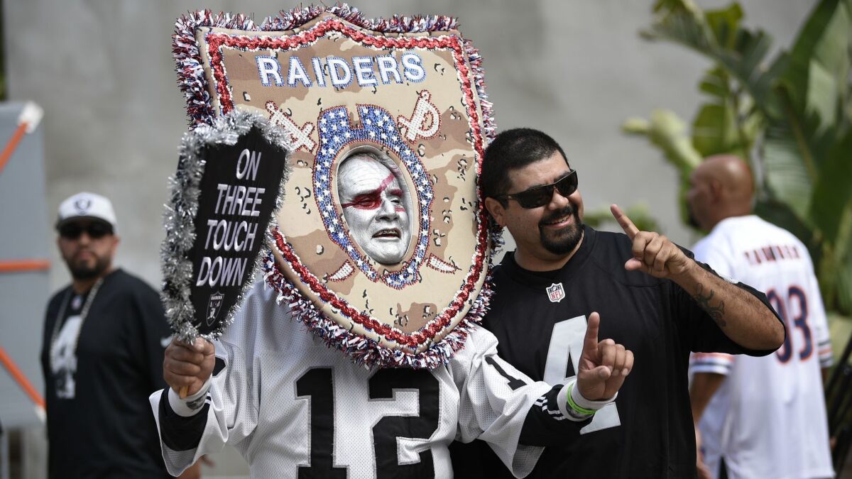 Oakland Raider fans pose before the game.