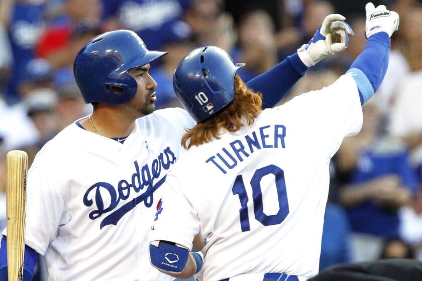 Los Angeles Dodgers' Adrian Gonzalez, left, takes a pretend selfie with Justin Turner after Turner returns after hitting a two-run home run against the San Francisco Giants during the fifth inning on Sunday. The Dodgers roll the Giants, 10-2.