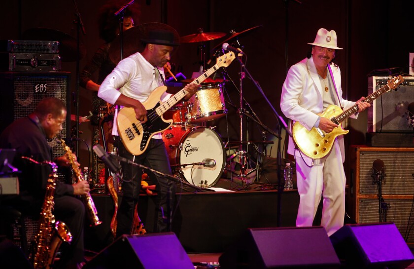 Carlos Santana, right, with Marcus Miller on bass and Wayne Shorter, left, onstage at the Hollywood Bowl Wednesday night.