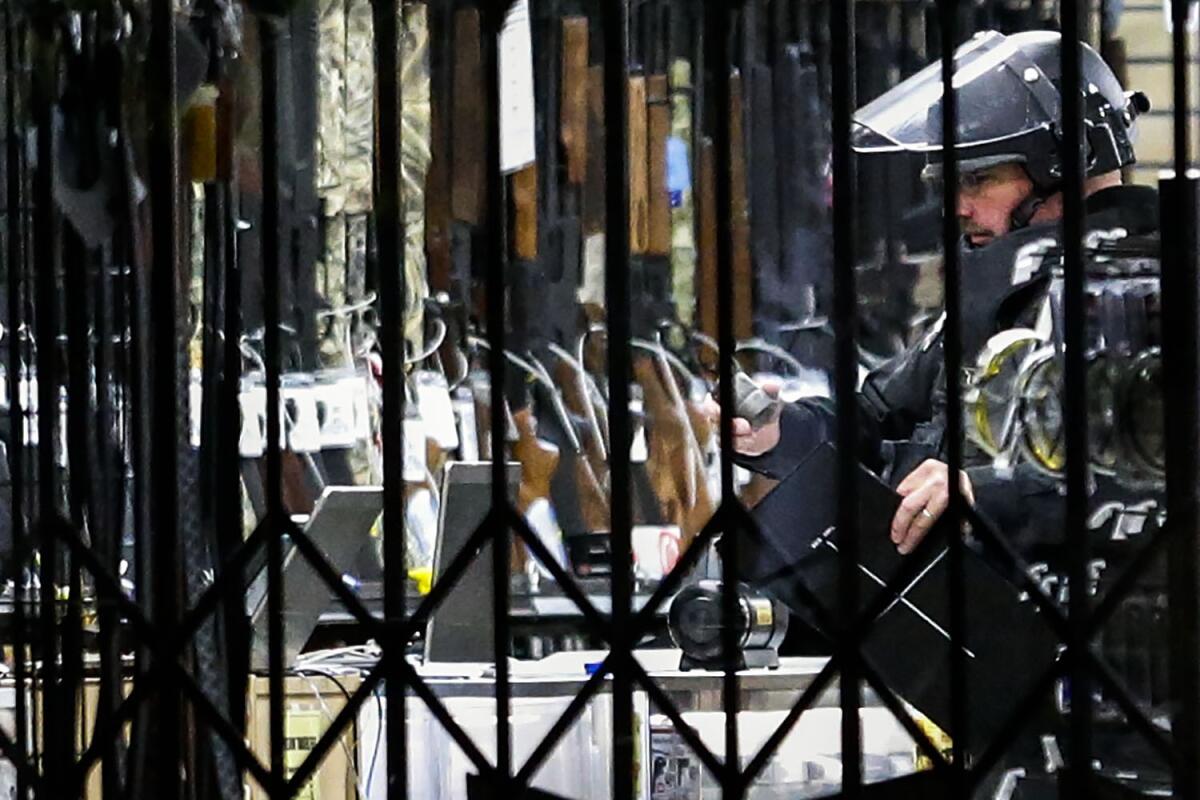 A L.A. County Sheriff's Department bomb squad member examines unidentified military ordnance inside the Turner's Outdoorsman store in Torrance on Saturday.