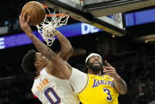 Los Angeles Lakers forward Anthony Davis gets off a shot against Phoenix Suns forward Ryan Dunn (0) during the first half of an NBA preseason basketball game Thursday, Oct. 17, 2024, in Phoenix. (AP Photo/Ross D. Franklin)