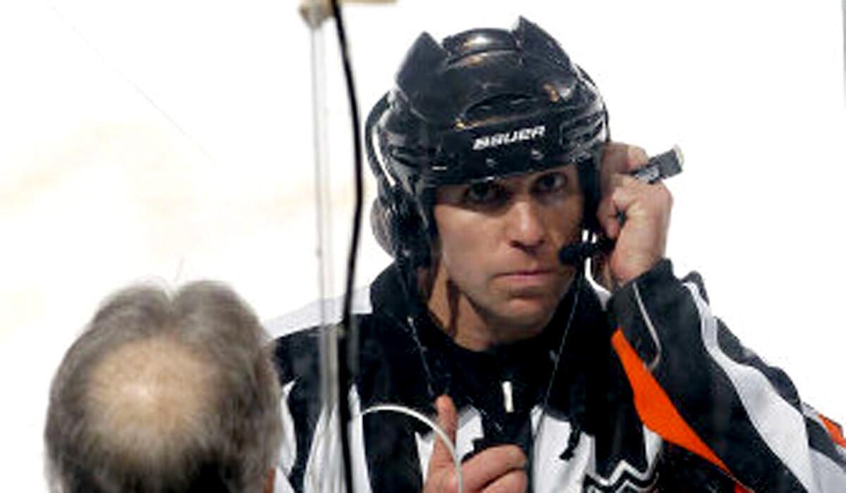 Referee Brian Pochmara awaits word on a video review during a Panthers-Lightning game.