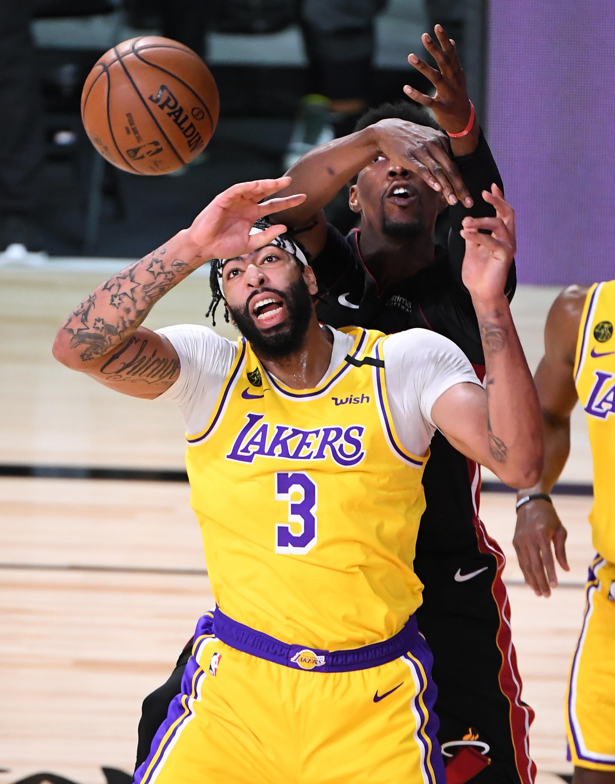 Lakers forward Anthony Davis and Heat center Bam Adebayo collide as they battle for a rebound during Game 1.