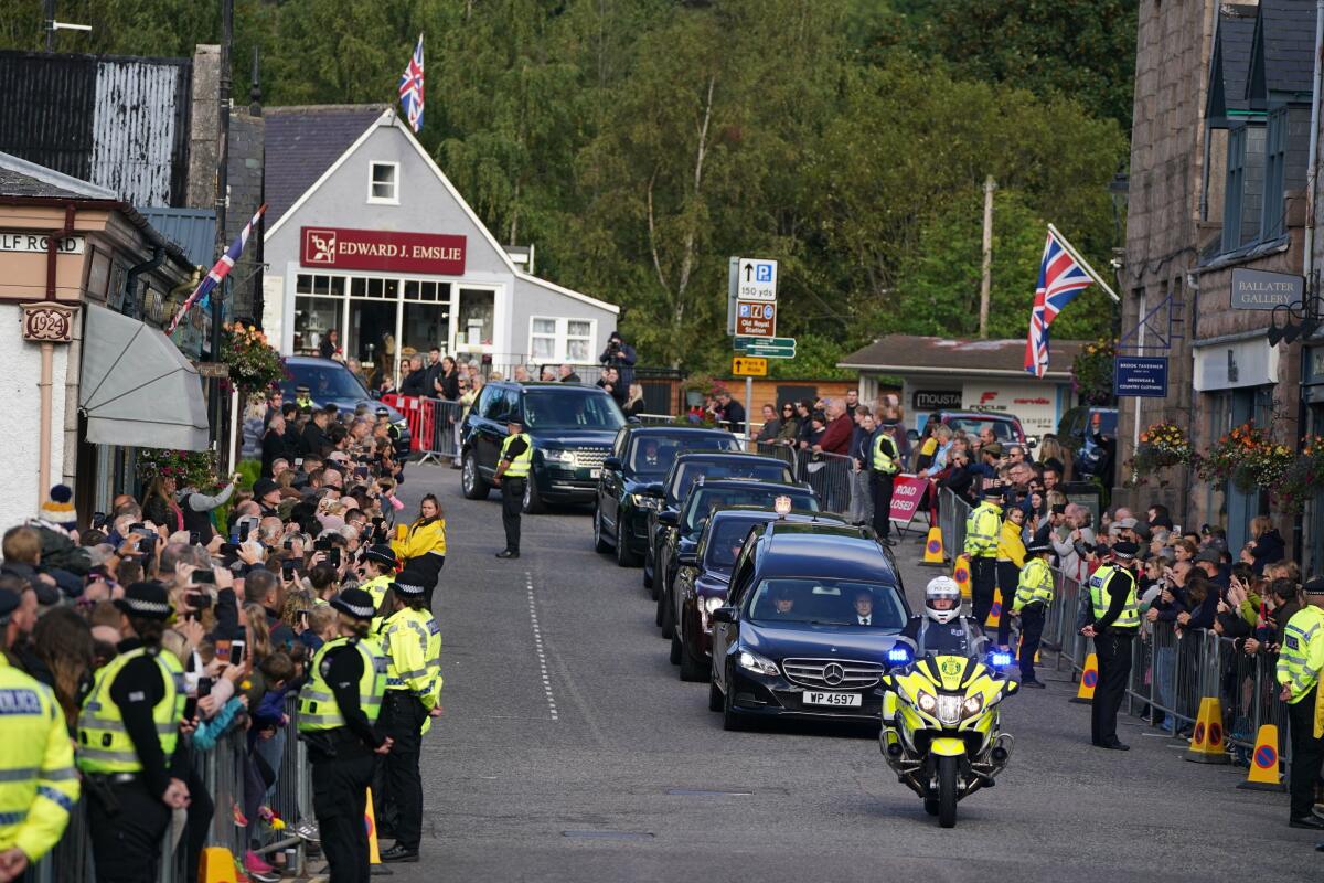People line the streets in Ballater, Scotland, as the hearse carrying the coffin of Queen Elizabeth II passes through.