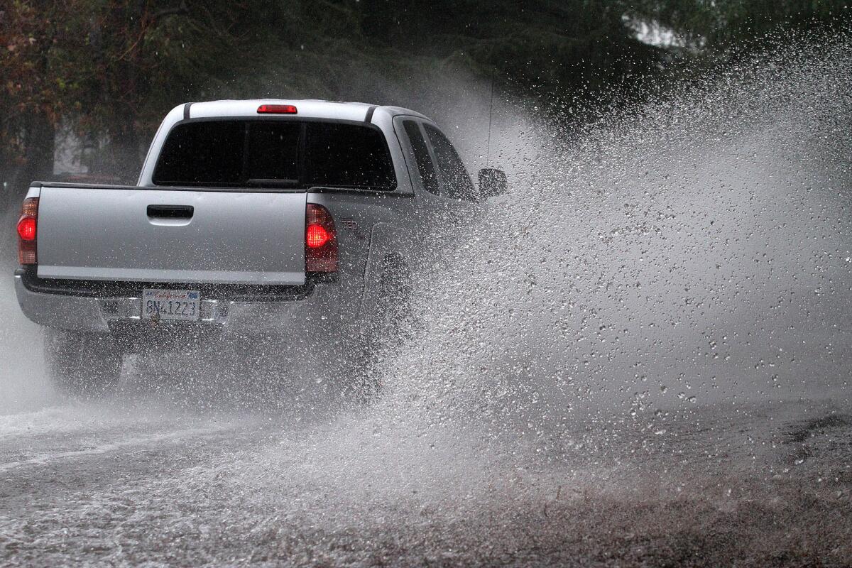 Cars and trucks on Ocean View Boulevard in La Cañada Flintridge, near the Glendale area, drive through a strong current of water running down the middle of the road on Friday, Feb. 28, 2014. Periodic heavy rain continued through the weekend.