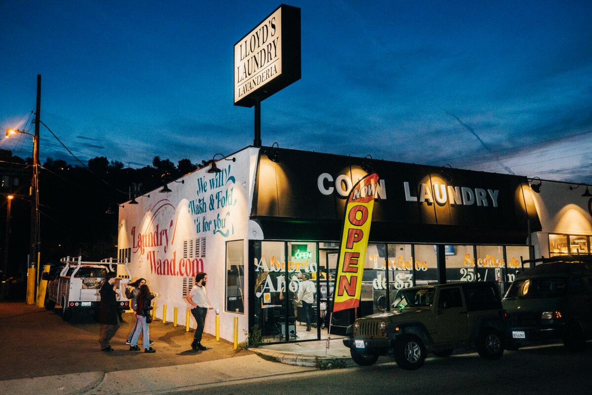 The exterior of a laundromat lighted up at twilight